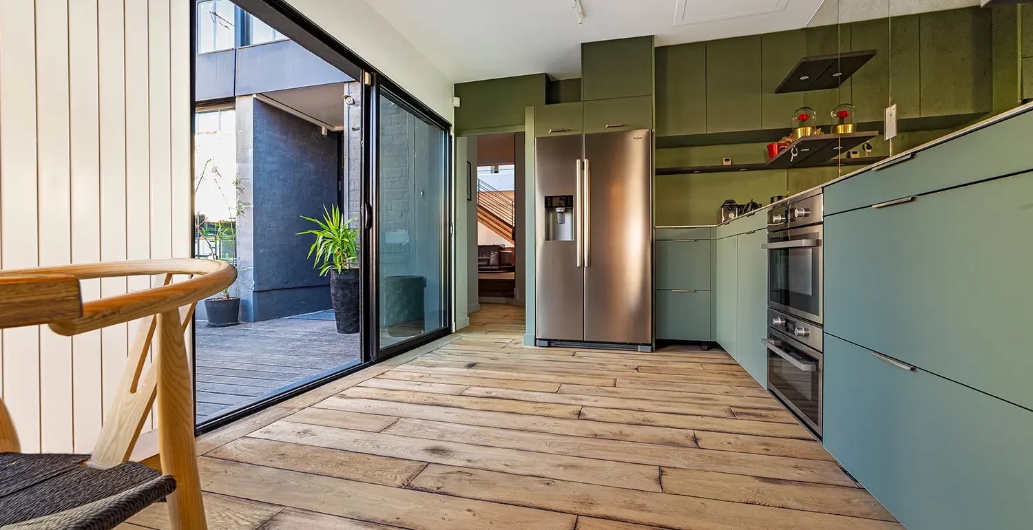 Aménagement bois global dans un loft d'architecte à Bagnolet : parquet chêne brut, marches intégrées et mur en bois brûlé