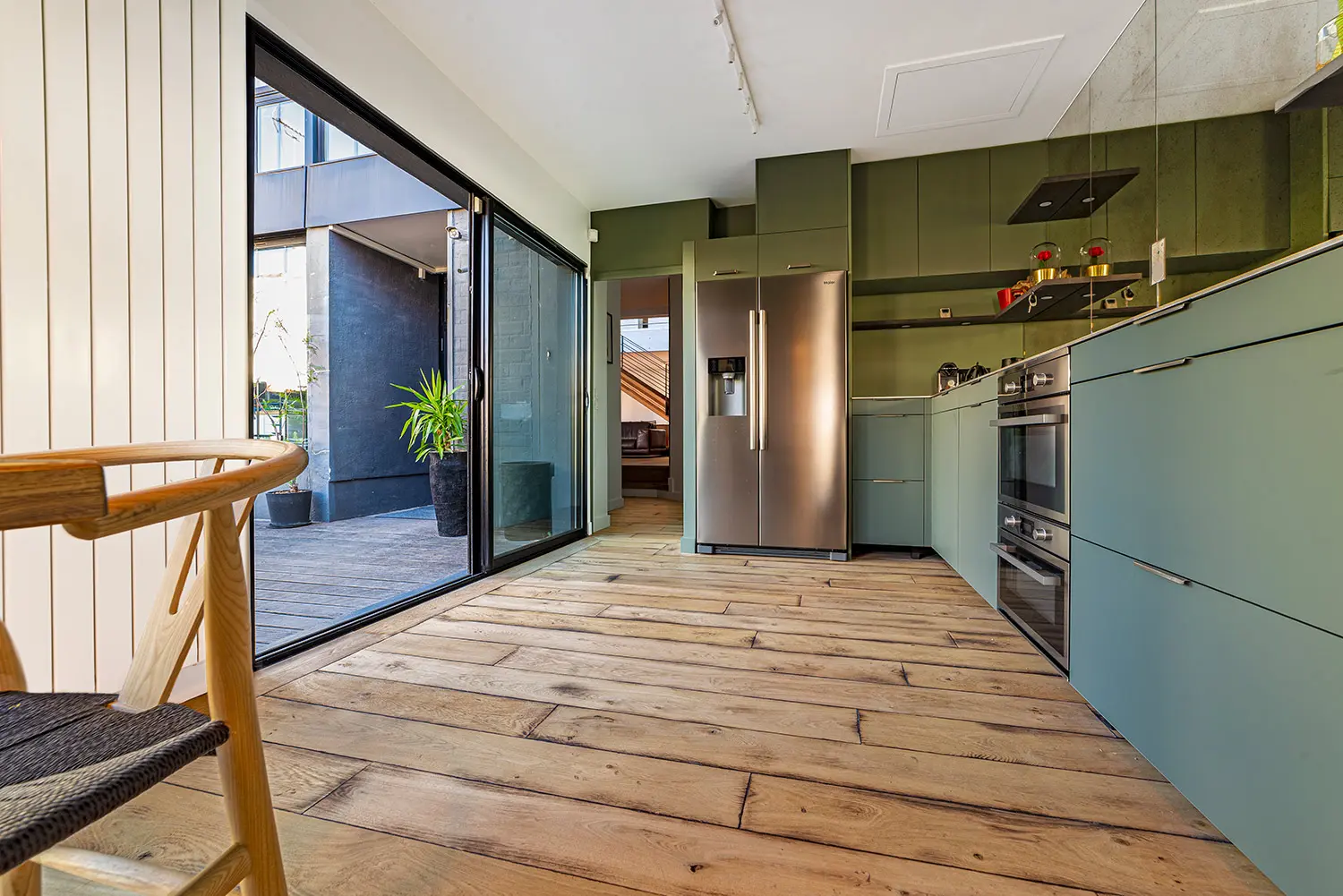 Aménagement bois global dans un loft d'architecte à Bagnolet : parquet chêne brut, marches intégrées et mur en bois brûlé