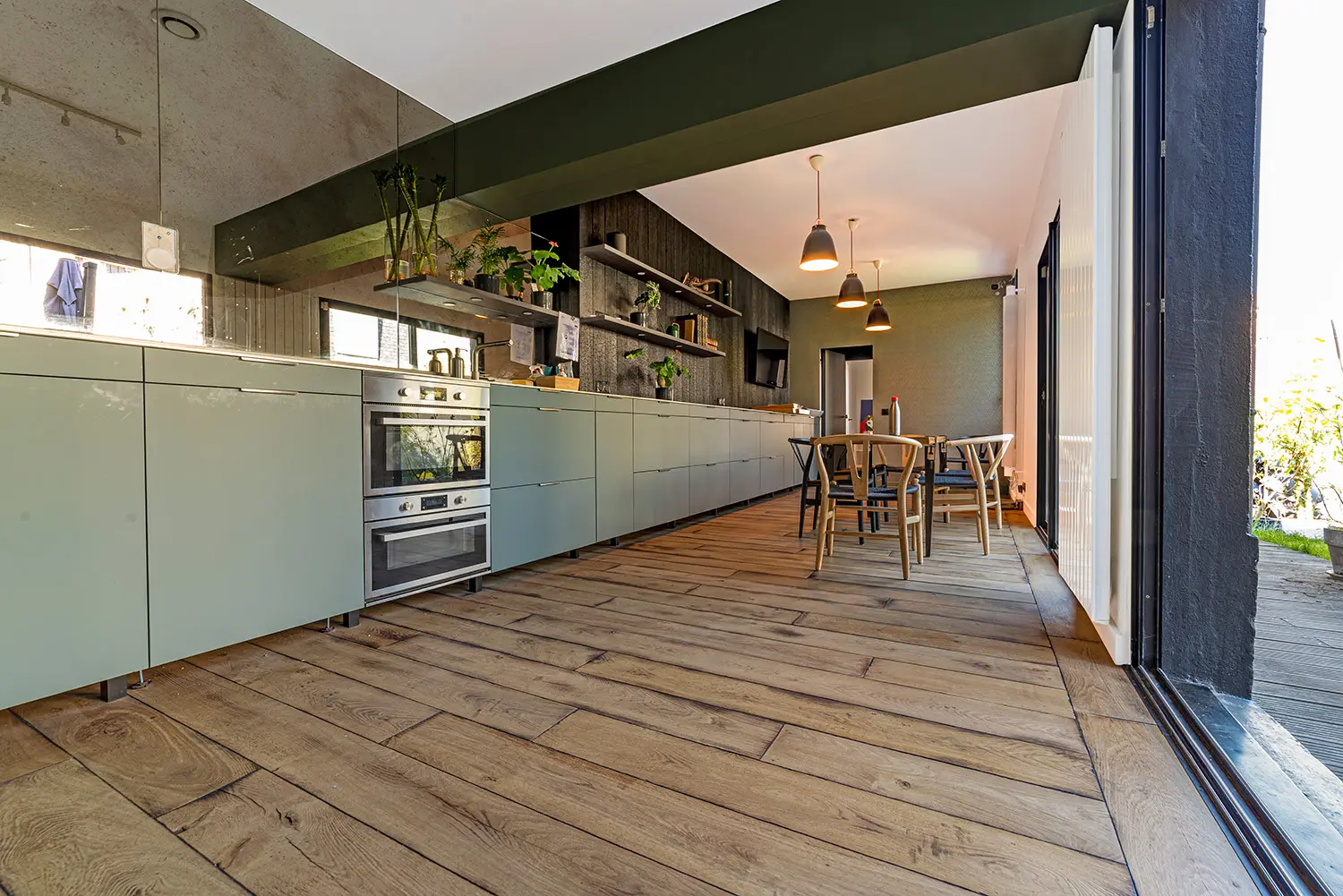 Parquet chêne brut s'ouvrant sur la terrasse extérieure dans la cuisine du loft d'architecte